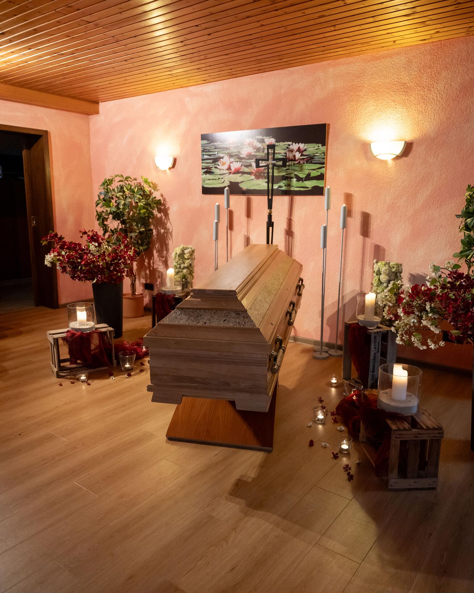 Abschiedsraum im Haus mit Sarg, Kerzen und Blumenschmuck